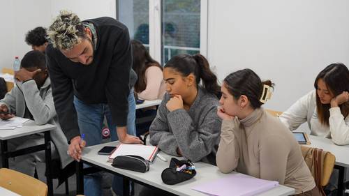 Professeur accompagnant des étudiantes en classe